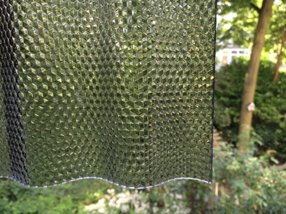 Bild mit Acryl-Lichtplatte in Graphit mit Wabenstruktur welches die Lichtdurchlässigkeit demonstriert.